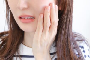 歯をおさえる女性